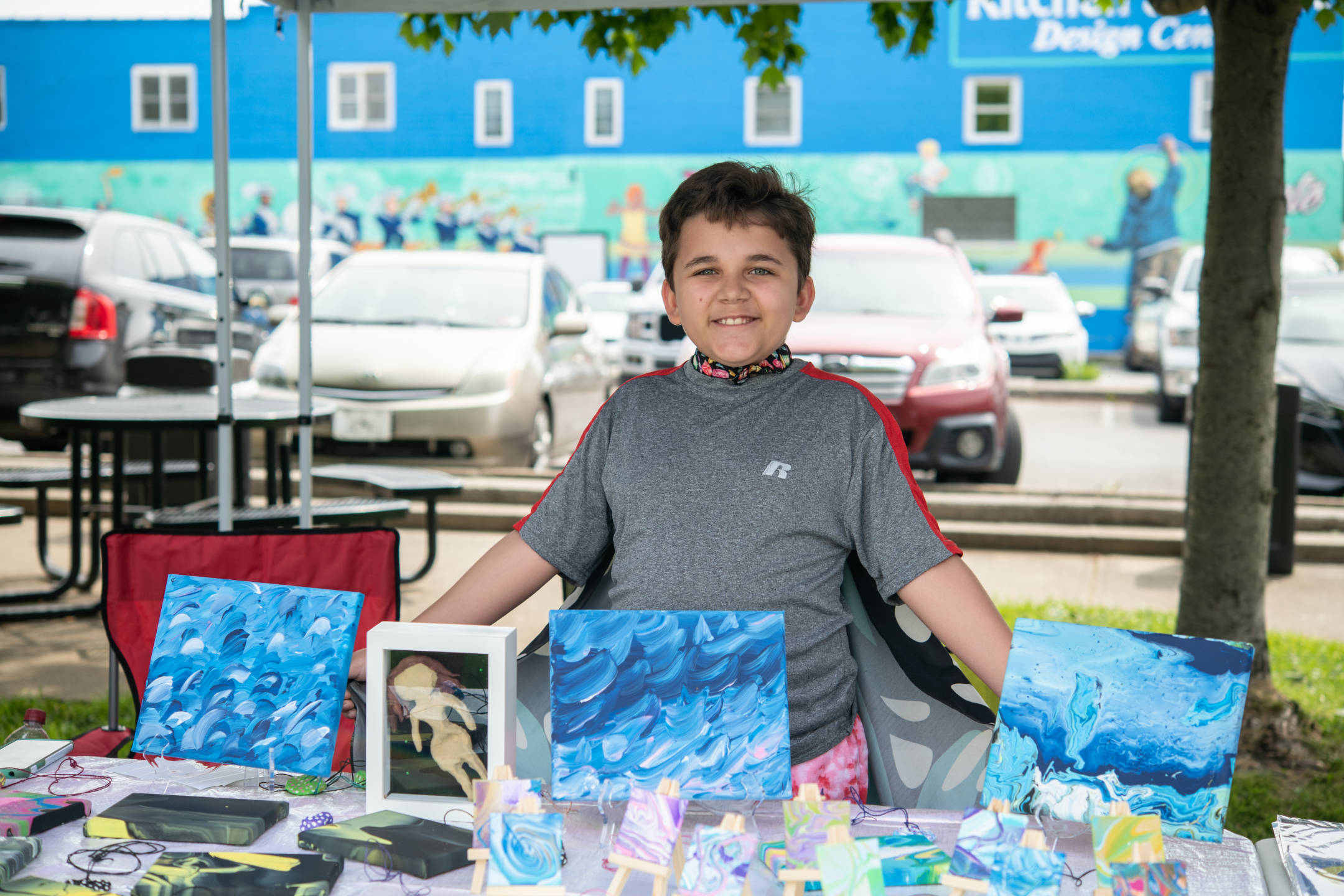 Young resident shows off his artwork at All Together Arts Week in Princeton
