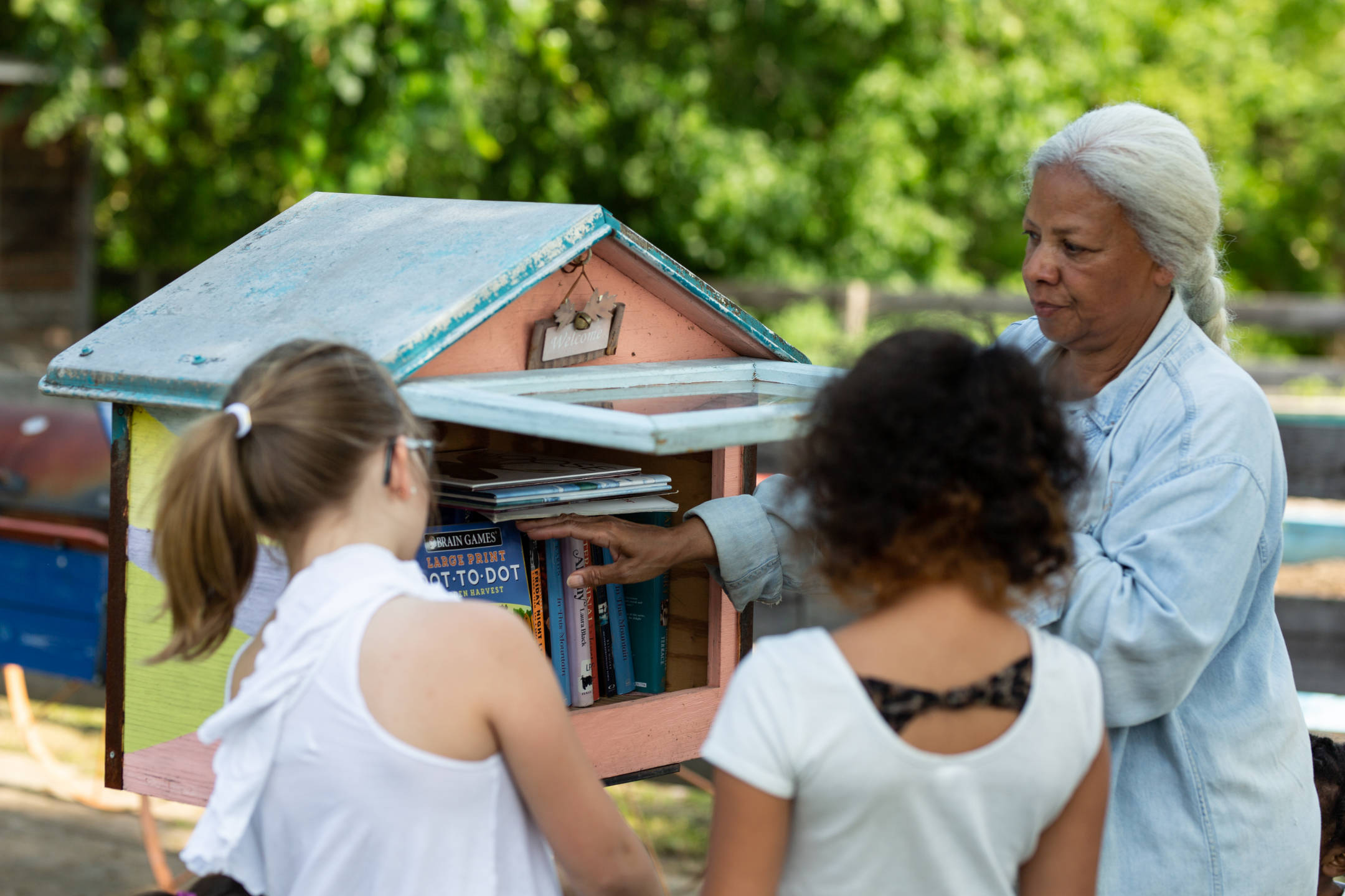 Residents refill a Free Little Library at the community garden in the Monticello neighborhood of Clarksburg